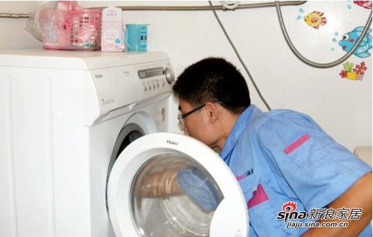 海尔售后服务人员正在对洗衣机进行细致的维护和保养